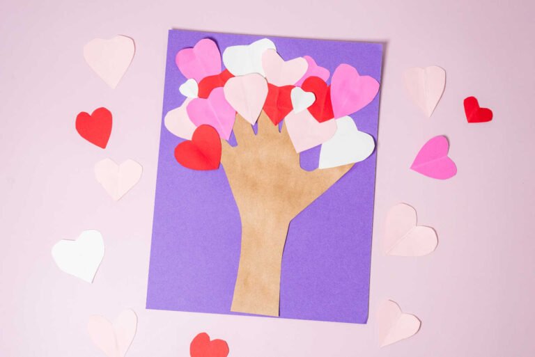 Finished heart tree craft with handprint trunk and colorful paper heart leaves.
